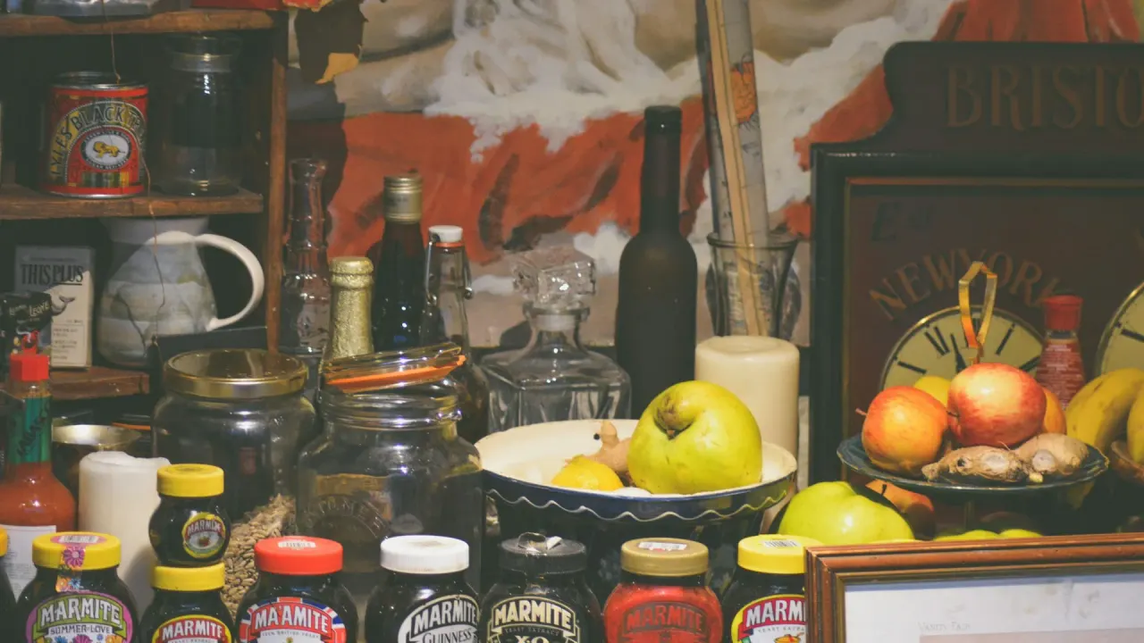 Jars, pantry staples and fruit arranged on kitchen shelves