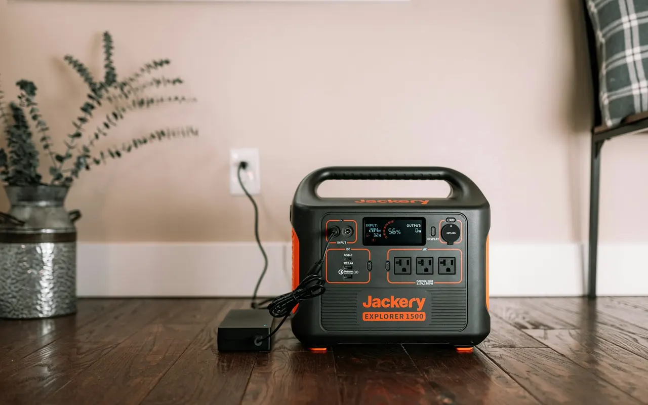 A portable Jackery battery with its charging adapter in a home