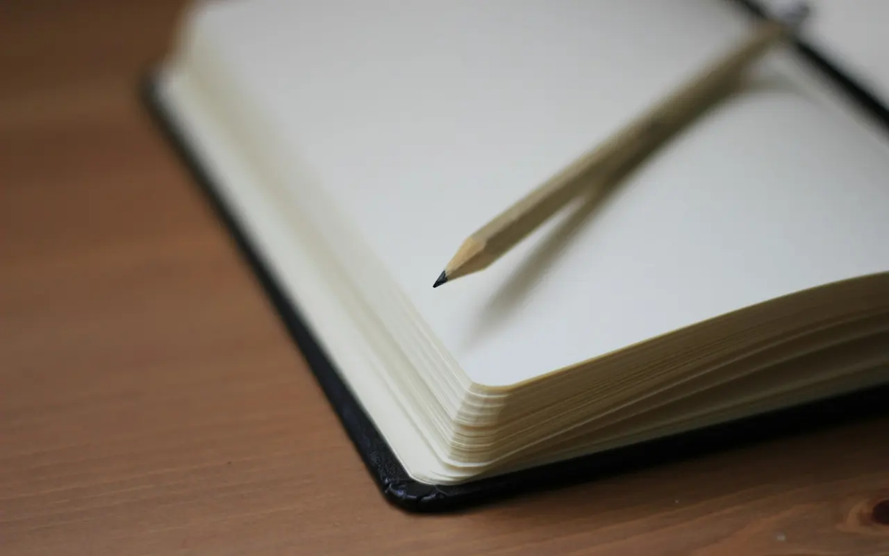 A pencil resting across an open notebook